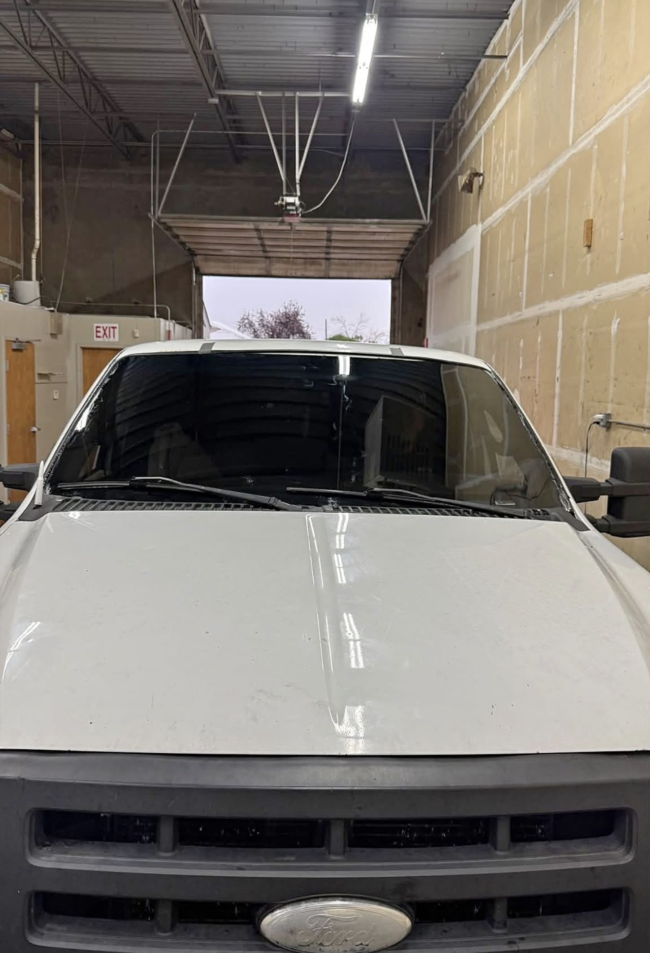 Truck with fresh windshield tint strip inside Tinty's install bay in Arvada, Colorado